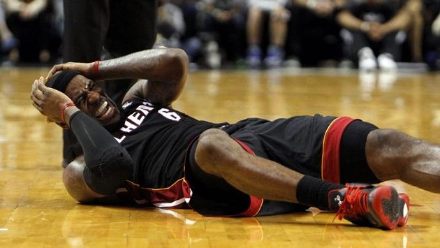 LeBron James z Miami Heat leží na palubovce po kolizi se soupeřem z Phoenixu. LeBron James z Miami Heat leží na palubovce po kolizi se soupeřem z Phoenixu.