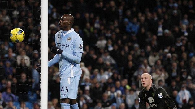 Útočním Manchesteru City Mario Balotelli (vlevo) střílí do sítě brankáře Norwiche Johna Ruddyho branku ramenem. Útočním Manchesteru City Mario Balotelli (vlevo) střílí do sítě brankáře Norwiche Johna Ruddyho branku ramenem.