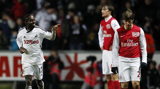 Nathan Dyer ze Swansea (vlevo) oslavuje gól vstřelený Arsenalu. Hráči Kanonýrů Andrej Aršavin (vpravo) a Ignasi Miquel neskrývají zklamání. Nathan Dyer ze Swansea (vlevo) oslavuje gól vstřelený Arsenalu. Hráči Kanonýrů Andrej Aršavin (vpravo) a Ignasi Miquel neskrývají zklamání.