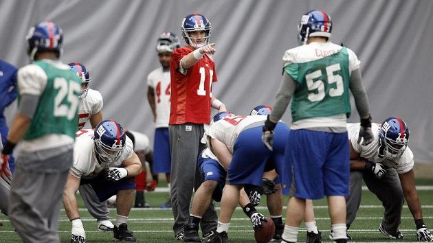 Quarterback New York Giants Eli Manning (s čílsem 10) organizuje spoluhráče během tréninku na 66. Super Bowl. Quarterback New York Giants Eli Manning (s čílsem 10) organizuje spoluhráče během tréninku na 66. Super Bowl.