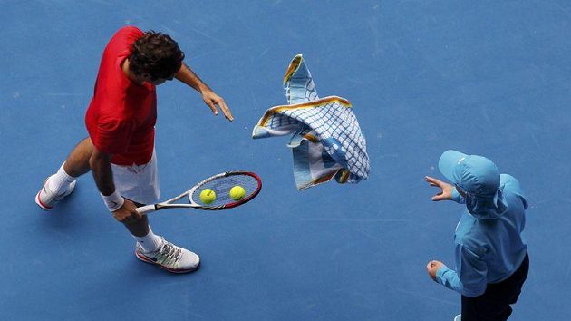 Roger Federer hází ručník sběrači míčků. Roger Federer hází ručník sběrači míčků.