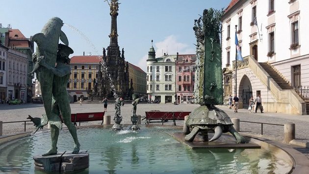 Ariónova kašna na Horním náměstí: Mladík ždímající delfína, želva A'Tuin nesoucí Zeměplochu v 90stupňovém úhlu na hřbetě. Ariónova kašna na Horním náměstí: Mladík ždímající delfína, želva A'Tuin nesoucí Zeměplochu v 90stupňovém úhlu na hřbetě.