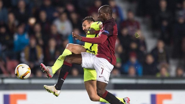 Sparťanský fotbalista Kehinde Fatai v souboji s obráncem Tripolisu Kostasem Giannoulisem během utkání Evropské ligy. Sparťanský fotbalista Kehinde Fatai v souboji s obráncem Tripolisu Kostasem Giannoulisem během utkání Evropské ligy.