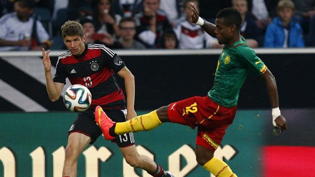 Němec Thomas Müller (vlevo) sleduje Henriho Bedima z Kamerunu, jak zpracovává míč v přípravném utkání před MS v Brazílii. Němec Thomas Müller (vlevo) sleduje Henriho Bedima z Kamerunu, jak zpracovává míč v přípravném utkání před MS v Brazílii.