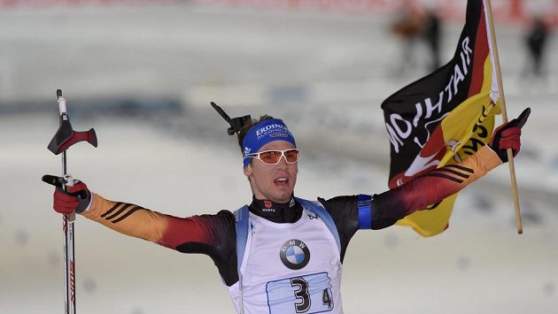 Německý biatlonista Simon Schempp slaví s vlajkou vítězství ve štafetě. Německý biatlonista Simon Schempp slaví s vlajkou vítězství ve štafetě.