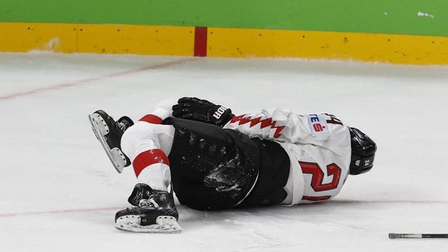 Rakouský hokejista Steven Strong leží na ledě po faulu Svena Andrighettiho v zápase se Švýcarskem. Rakouský hokejista Steven Strong leží na ledě po faulu Svena Andrighettiho v zápase se Švýcarskem.