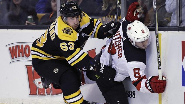 Hokejista Bostonu Bruins Brad Marchand (63) napadá obránce New Jersey Devils Willa Butchera (8). Hokejista Bostonu Bruins Brad Marchand (63) napadá obránce New Jersey Devils Willa Butchera (8).