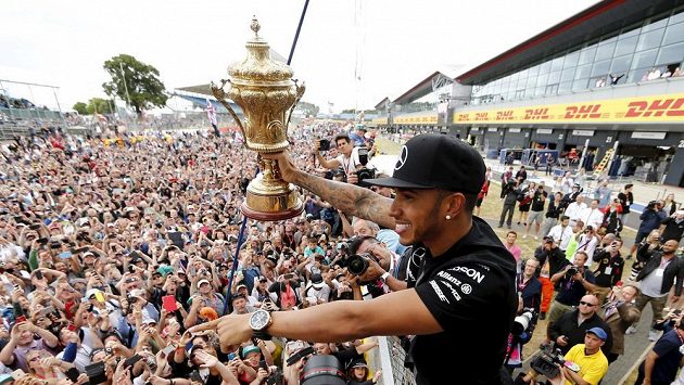 Britský jezdec F1 Lewis Hamilton ze stáje Mercedes slaví s fanoušky vítězství v Silverstonu. Britský jezdec F1 Lewis Hamilton ze stáje Mercedes slaví s fanoušky vítězství v Silverstonu.