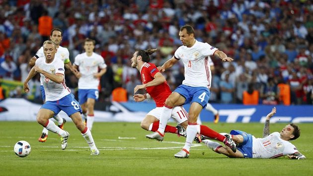 Rus Sergej Ignaševič zastavuje unikajícího Garetha Balea z Walesu. Rus Sergej Ignaševič zastavuje unikajícího Garetha Balea z Walesu.