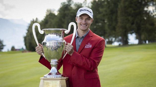 Rasmus Höjgaard z Dánska pózuje s trofejí pro vítěze turnaje v Crans Montaně v rámci European Tour. Naváže na triumf tento týden jeho dvojče Nicolai? Rasmus Höjgaard z Dánska pózuje s trofejí pro vítěze turnaje v Crans Montaně v rámci European Tour. Naváže na triumf tento týden jeho dvojče Nicolai?