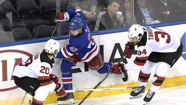 Český obránce NY Rangers Libor Hájek (v modrém) mezi Blakeam Colemanem (20) a Ericem Tangradim (34) během třetí třetiny utkání NHL mezi NY Rangers a New Jersey. Český obránce NY Rangers Libor Hájek (v modrém) mezi Blakeam Colemanem (20) a Ericem Tangradim (34) během třetí třetiny utkání NHL mezi NY Rangers a New Jersey.