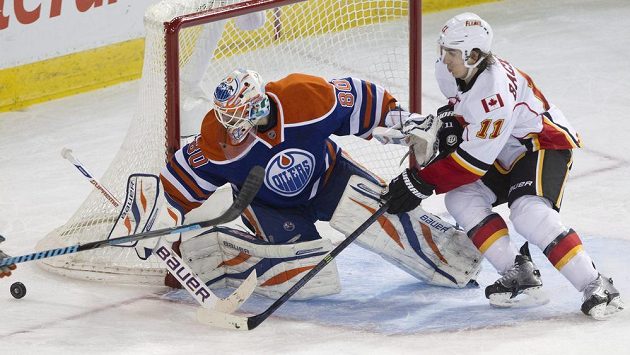 Ilja Bryzgalov ještě v brance Edmontonu zasahuje před Mikaelem Bäcklundem z Calgary. Ilja Bryzgalov ještě v brance Edmontonu zasahuje před Mikaelem Bäcklundem z Calgary.
