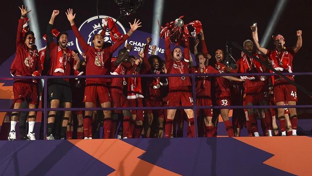 Liverpoolský Jordan Henderson s trofejí pro vítěze Premier League. Liverpoolský Jordan Henderson s trofejí pro vítěze Premier League.
