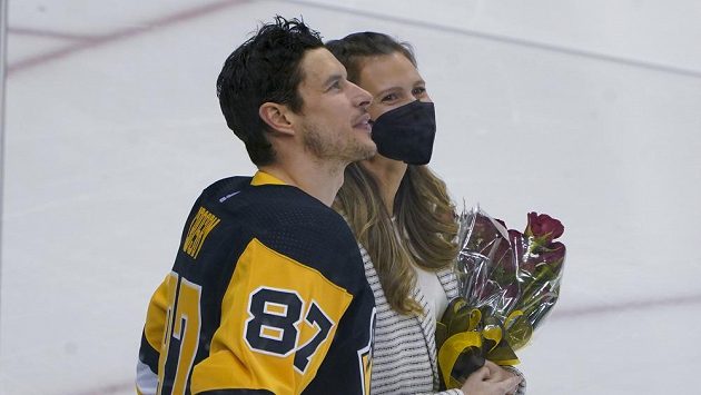 Sidney Crosby s dlouholetou přítelkyní Kathy Leutnerovou sleduje na kostce záběry při ceremoniálu na počest 1000. utkání v NHL. Sidney Crosby s dlouholetou přítelkyní Kathy Leutnerovou sleduje na kostce záběry při ceremoniálu na počest 1000. utkání v NHL.