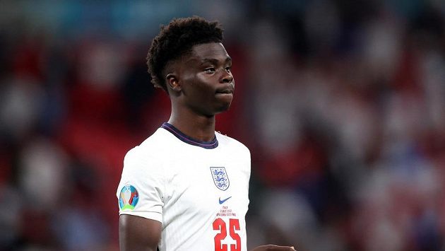 Zdrcený anglický reprezentant Bukayo Saka po neproměněné penaltě v rozstřelu finále EURO. Po něm se stal terčem rasistických urážek. Zdrcený anglický reprezentant Bukayo Saka po neproměněné penaltě v rozstřelu finále EURO. Po něm se stal terčem rasistických urážek.