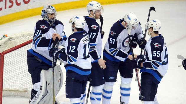 Útočník Winnipegu Drew Stafford (druhý zleva) gratuluje po utkání v Minnesotě brankáři Ondřeji Pavelcovi k vychytané nule. Útočník Winnipegu Drew Stafford (druhý zleva) gratuluje po utkání v Minnesotě brankáři Ondřeji Pavelcovi k vychytané nule.