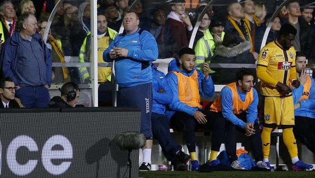 Náhradní brankář Suttonu Wayne Shaw i během zápasu s Arsenalem stihl posvačit. Náhradní brankář Suttonu Wayne Shaw i během zápasu s Arsenalem stihl posvačit.