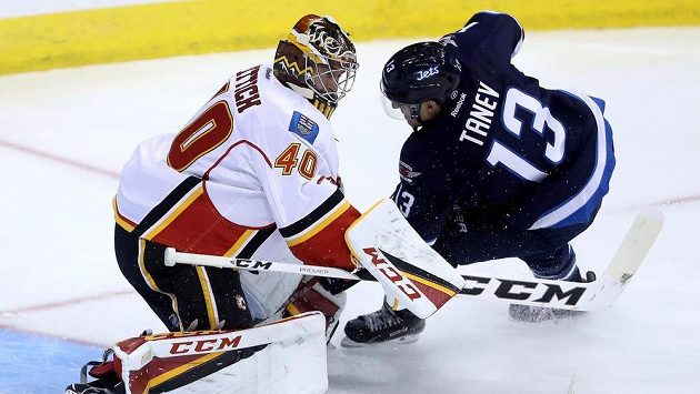 Brankáře Calgary Davida Ritticha (40) se snaží překonat Brandon Tanev z Winnipegu. Brankáře Calgary Davida Ritticha (40) se snaží překonat Brandon Tanev z Winnipegu.
