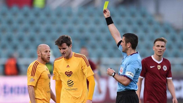 Rozhodčí Martin Nenadal ukazuje žlutou kartu Marku Hanouskovi z Dukly (druhý zleva). Rozhodčí Martin Nenadal ukazuje žlutou kartu Marku Hanouskovi z Dukly (druhý zleva).