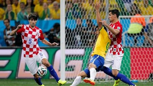 Brazilský útočník Fred (ve žlutém dresu) padá k zemi po souboji s chorvatským stoperem Dejanem Lovrenem (vpravo). Japonský sudí Nišimura nařídil pokutový kop pro domácí Kanárky. Brazilský útočník Fred (ve žlutém dresu) padá k zemi po souboji s chorvatským stoperem Dejanem Lovrenem (vpravo). Japonský sudí Nišimura nařídil pokutový kop pro domácí Kanárky.
