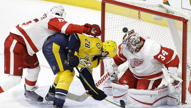 Český gólman Petr Mrázek (34) z Detroitu Red Wings za pomoci zadáka Dannyho DeKeysera (65) likviduje pokus Paula Gaustada (28) z Nashvillu. Český gólman Petr Mrázek (34) z Detroitu Red Wings za pomoci zadáka Dannyho DeKeysera (65) likviduje pokus Paula Gaustada (28) z Nashvillu.