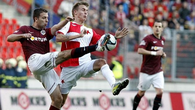 Sparťan Hušbauer ukopává míč před slávistou Petrákem v pražském derby. Sparťan Hušbauer ukopává míč před slávistou Petrákem v pražském derby.
