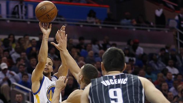 Stephen Curry z Golden State Warriors (vlevo) střílí za tři body v zápase s Orlandem. Stephen Curry z Golden State Warriors (vlevo) střílí za tři body v zápase s Orlandem.