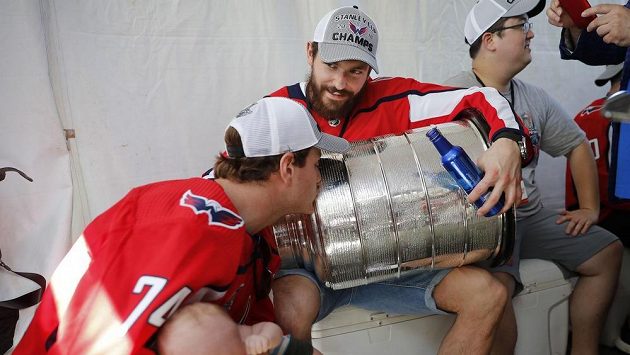 Washingtonský John Carlson (74) líbá Stanley Cup, který drží český bek Michal Kempný. Washingtonský John Carlson (74) líbá Stanley Cup, který drží český bek Michal Kempný.
