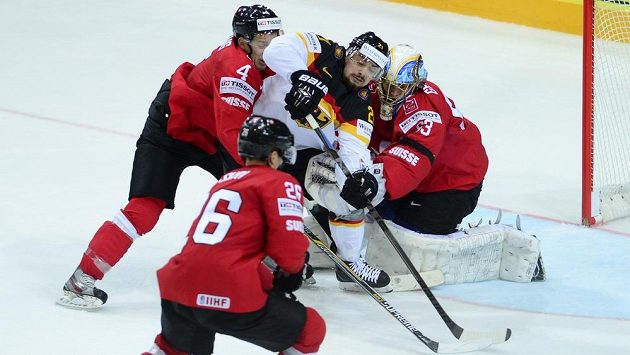 Švýcarští hokejisté Patrick Geering a Reto Suri (zleva) v klinči s Němcem Nicolasem Krammerer před švýcarskou bránou střeženou Leonardem Genonim. Švýcarští hokejisté Patrick Geering a Reto Suri (zleva) v klinči s Němcem Nicolasem Krammerer před švýcarskou bránou střeženou Leonardem Genonim.