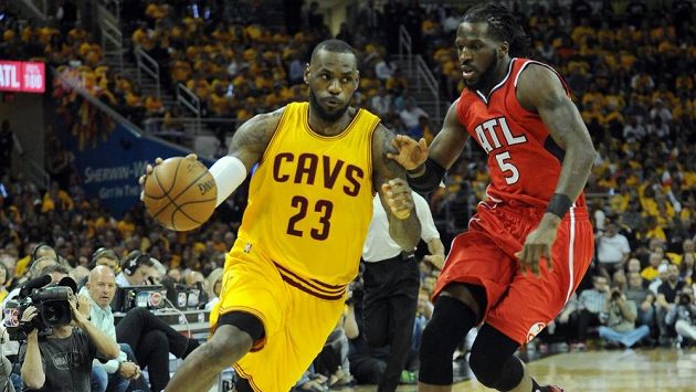 Basketbalista Clevelandu LeBron James (vlevo) si kryje míč před Carrollem z Atlanty. Basketbalista Clevelandu LeBron James (vlevo) si kryje míč před Carrollem z Atlanty.