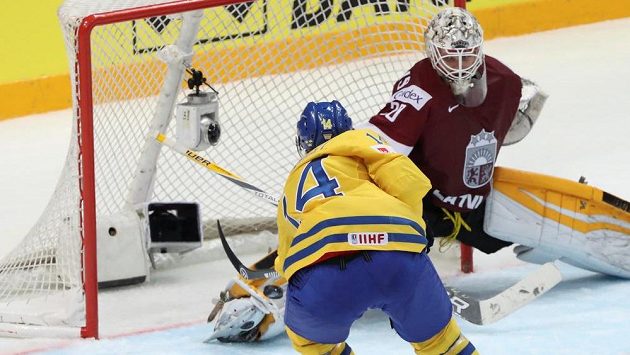 Švéd Gustav Nyquist střílí rozhodující gól lotyšskému brankáři Elvisovi Merzlikinšovi. Švéd Gustav Nyquist střílí rozhodující gól lotyšskému brankáři Elvisovi Merzlikinšovi.