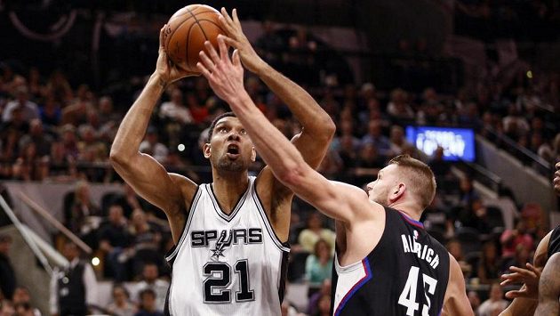 Tim Duncan (21) ze San Antonia, ve střelbě mu brání Cole Aldrich (45) z LA Clippers. Tim Duncan (21) ze San Antonia, ve střelbě mu brání Cole Aldrich (45) z LA Clippers.