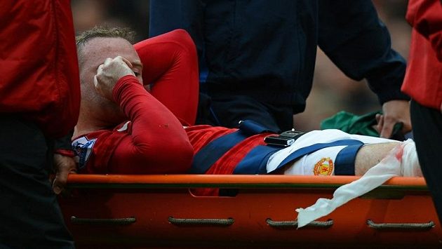 Zraněný Wayne Rooney opouští hřiště na nosítkách Zraněný Wayne Rooney opouští hřiště na nosítkách