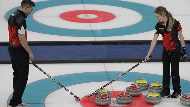 Kanadská dvojice John Morris a Kaitlyn Lawes se radí, kam umístí kámen. Kanadská dvojice John Morris a Kaitlyn Lawes se radí, kam umístí kámen.