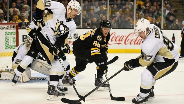 Útočník Bostonu David Pastrňák (uprostřed) mezi hráči pittsburghu Sidneym Crosbym (87) a Christianem Ehrhoffem (10). Útočník Bostonu David Pastrňák (uprostřed) mezi hráči pittsburghu Sidneym Crosbym (87) a Christianem Ehrhoffem (10).