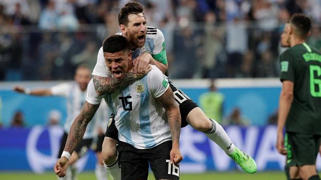 Argentinec Marcos Rojo slaví druhý gól proti Nigérii, na zádech má Lionela Messiho. Argentinec Marcos Rojo slaví druhý gól proti Nigérii, na zádech má Lionela Messiho.