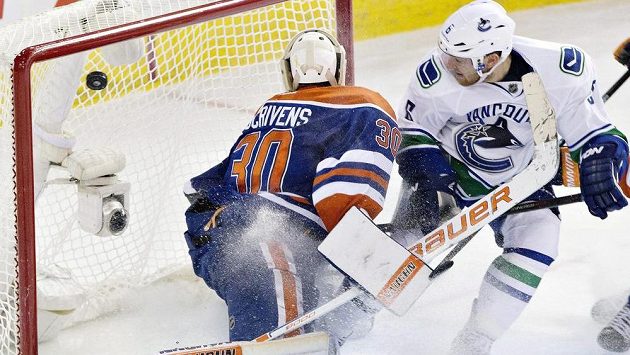 Hokejista Vancouveuru Canucks Yannick Weber (vpravo) dává gól brankáři Edmontonu Oilers Benu Scrivensovi. Hokejista Vancouveuru Canucks Yannick Weber (vpravo) dává gól brankáři Edmontonu Oilers Benu Scrivensovi.