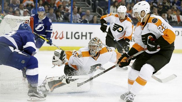 Útočník Tampy Ondřej Palát (vlevo) se snaží dopravit puk za záda brankáře Philadelphie Stevea Masona. Přihlíží forvard Flyers Claude Giroux (vpravo). Útočník Tampy Ondřej Palát (vlevo) se snaží dopravit puk za záda brankáře Philadelphie Stevea Masona. Přihlíží forvard Flyers Claude Giroux (vpravo).