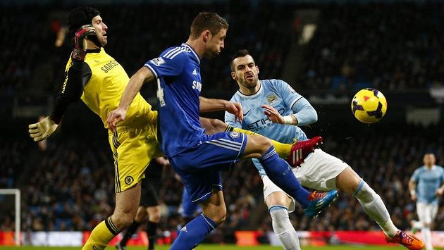 Brankář Chelsea Petr Čech ve spolupráci s obráncem Garym Cahillem odvrací míč před dotírajícím Alvarem Negredem (vpravo) z Manchesteru City. Brankář Chelsea Petr Čech ve spolupráci s obráncem Garym Cahillem odvrací míč před dotírajícím Alvarem Negredem (vpravo) z Manchesteru City.