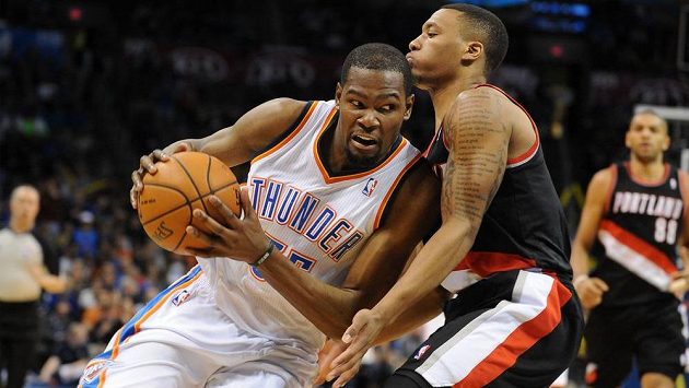 Kevin Durant (vlevo) z týmu Oklahomy zkouší projít přes bránícího Damiana Lillarda z Portlandu. Kevin Durant (vlevo) z týmu Oklahomy zkouší projít přes bránícího Damiana Lillarda z Portlandu.