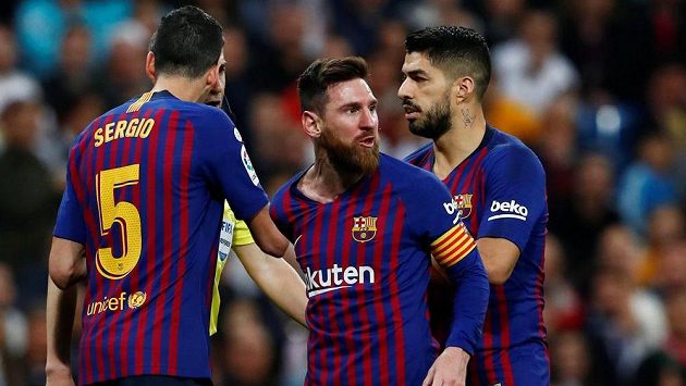 Barcelonský Lionel Messi (uprostřed) reaguje po střetu se Sergiem Ramosem z Realu. Barcelonský Lionel Messi (uprostřed) reaguje po střetu se Sergiem Ramosem z Realu.