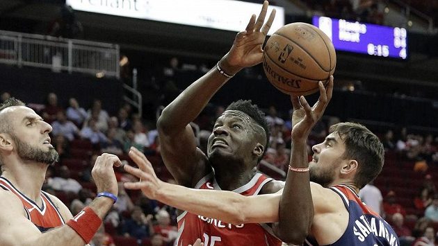 Clint Capela z týmu Houston Rockets se snaží vystřelit přes bránící hráče Washingtonu - Marcina Gortata a Tomáše Satoranského (vpravo) v utkání NBA. Clint Capela z týmu Houston Rockets se snaží vystřelit přes bránící hráče Washingtonu - Marcina Gortata a Tomáše Satoranského (vpravo) v utkání NBA.