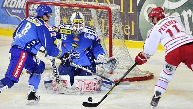 Brankář Komety Brno Jiří Trvaj zasahuje proti střele třineckého Jana Peterka. Brankář Komety Brno Jiří Trvaj zasahuje proti střele třineckého Jana Peterka.