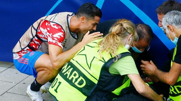 Cristiano Ronaldo z Manchesteru United u zasažené pořadatelky ležící na zemi. Cristiano Ronaldo z Manchesteru United u zasažené pořadatelky ležící na zemi.