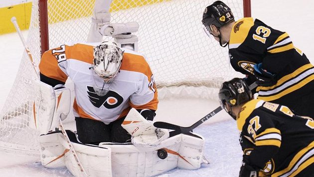 Brankář Philadelphie Flyers Carter Hart (79) likviduje šanci bostonského centra Charlieho Coyla (13), v akci je elitní útočník Bruins Patrice Bergeron (37). Brankář Philadelphie Flyers Carter Hart (79) likviduje šanci bostonského centra Charlieho Coyla (13), v akci je elitní útočník Bruins Patrice Bergeron (37).