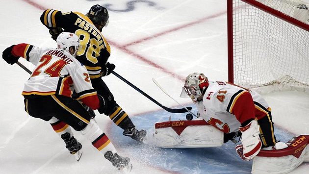 Český útočník Bostonu David Pastrňák překonává brankáře Calgary Mikea Smithe (41) v utkání NHL. Český útočník Bostonu David Pastrňák překonává brankáře Calgary Mikea Smithe (41) v utkání NHL.