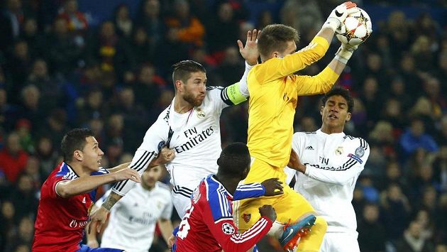 Brankář Basileje Tomáš Vaclík zasahuje před hráči Realu Madrid Sergiem Ramosem (s kapitánskou páskou) a Raphaelem Varanem. Vlevo je stoper Basileje Marek Suchý. Brankář Basileje Tomáš Vaclík zasahuje před hráči Realu Madrid Sergiem Ramosem (s kapitánskou páskou) a Raphaelem Varanem. Vlevo je stoper Basileje Marek Suchý.