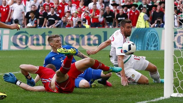 Islanďan Birkir Saevarsson (v modrém dresu) vlastním gólem srovnává na 1:1 bitvu s Maďary. Vpravo Daniel Bode, vlevo brankář Hannes Halldorsson. Islanďan Birkir Saevarsson (v modrém dresu) vlastním gólem srovnává na 1:1 bitvu s Maďary. Vpravo Daniel Bode, vlevo brankář Hannes Halldorsson.