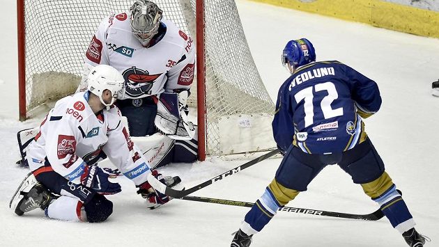 Brett Flemming z Chomutova, brankář Chomutova Justin Peters a Linus Svedlund z Kladna v akci během utkání baráže o hokejovou extraligu. Brett Flemming z Chomutova, brankář Chomutova Justin Peters a Linus Svedlund z Kladna v akci během utkání baráže o hokejovou extraligu.