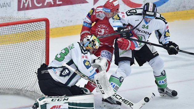 Brankář Mladé Boleslavi David Rittich (vlevo) sleduje puk, který se snaží dorazit Daniel Rákos z Třince (uprostřed. Vpravo Jan Holub z Boleslavi. Brankář Mladé Boleslavi David Rittich (vlevo) sleduje puk, který se snaží dorazit Daniel Rákos z Třince (uprostřed. Vpravo Jan Holub z Boleslavi.